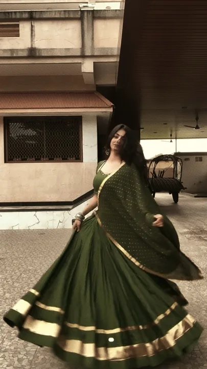 A woman spinning in a green traditional outfit in the Smooth Slowmo preview